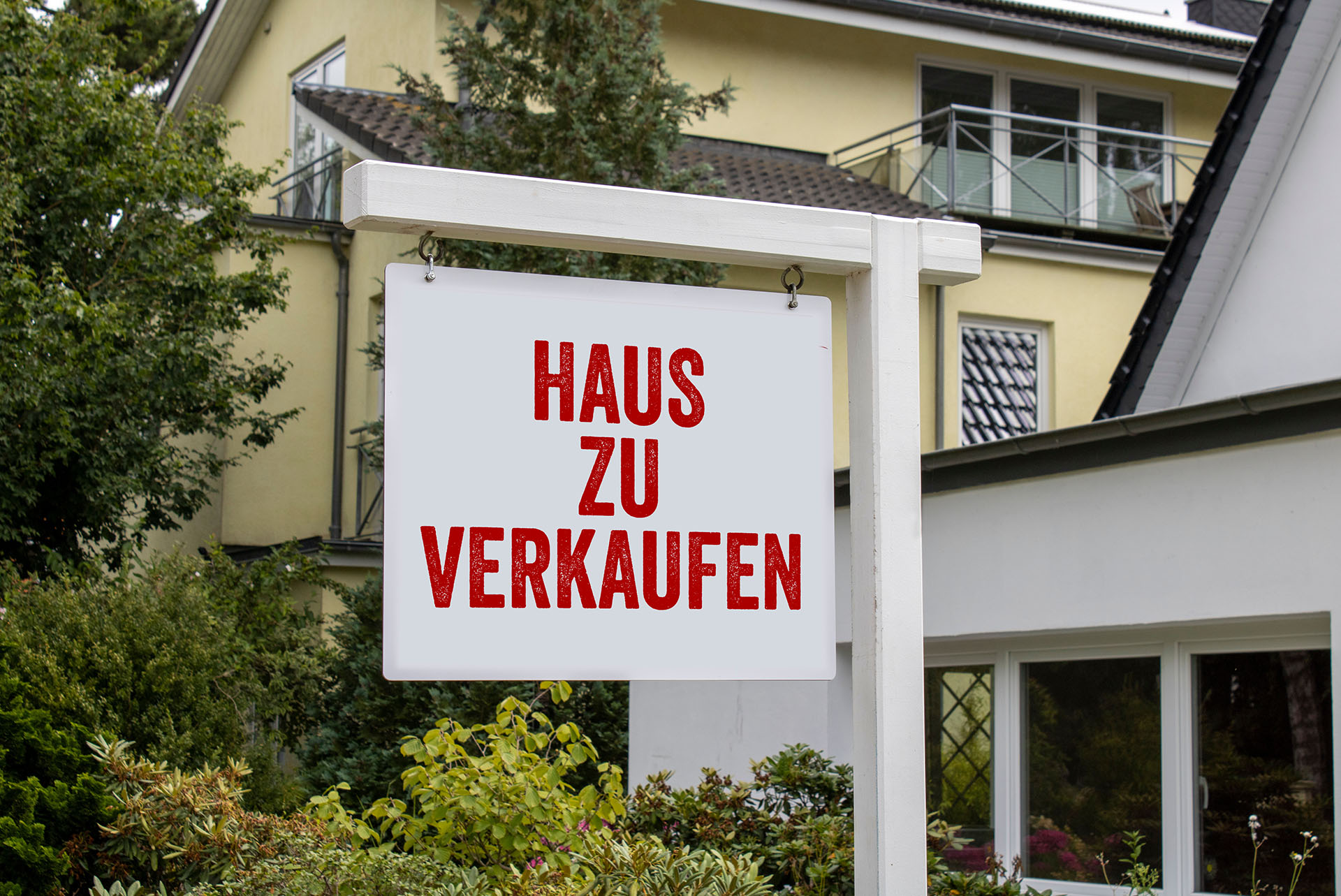 Schild "Haus zu verkaufen" vor Haus